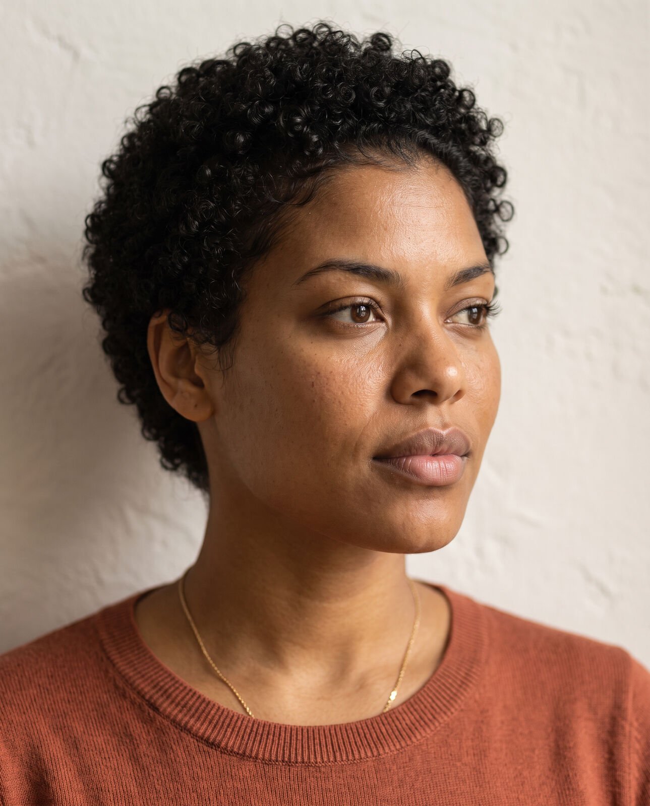 Close portrait of a woman with short curly hair in soft daylight