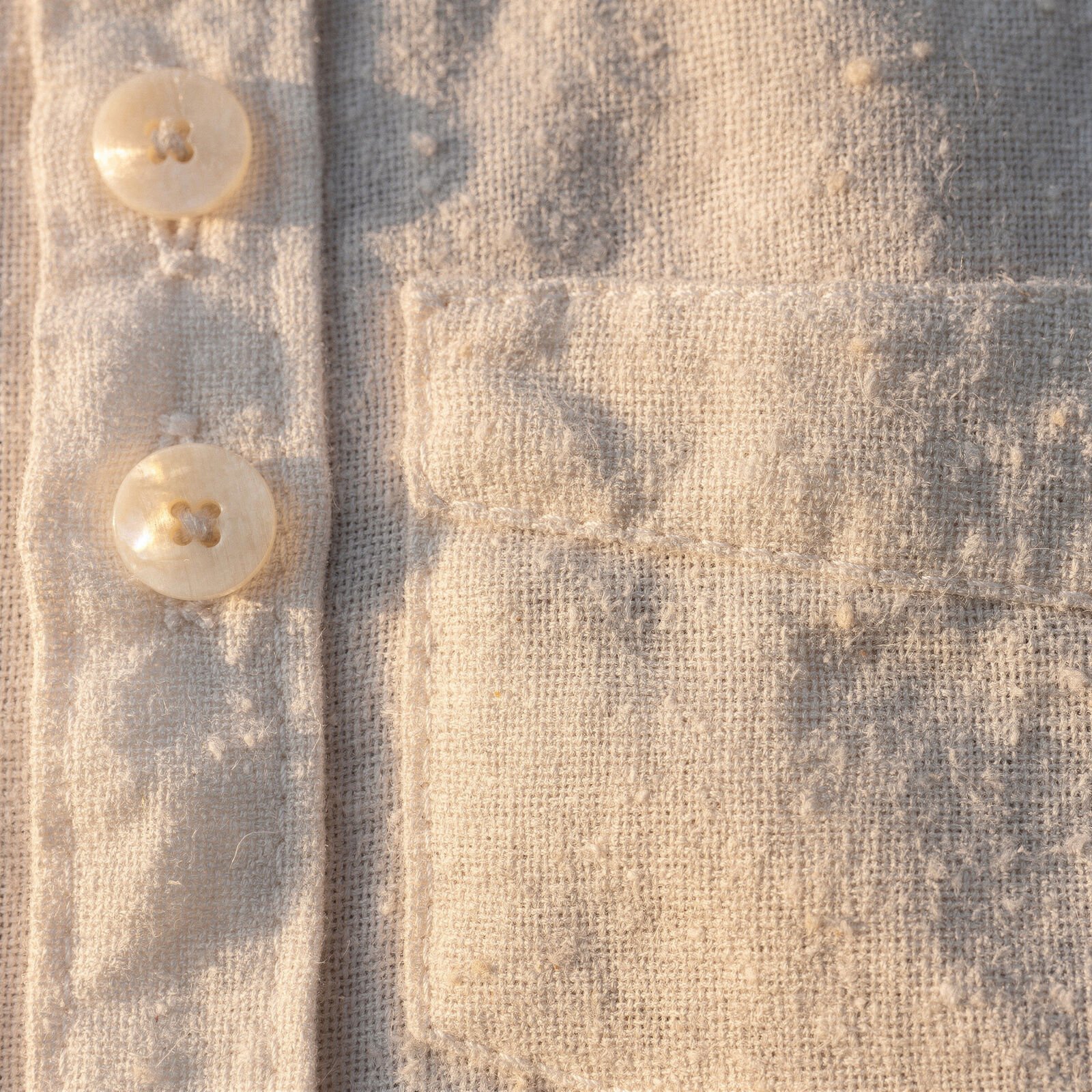 Linen weave and two shell buttons, close up